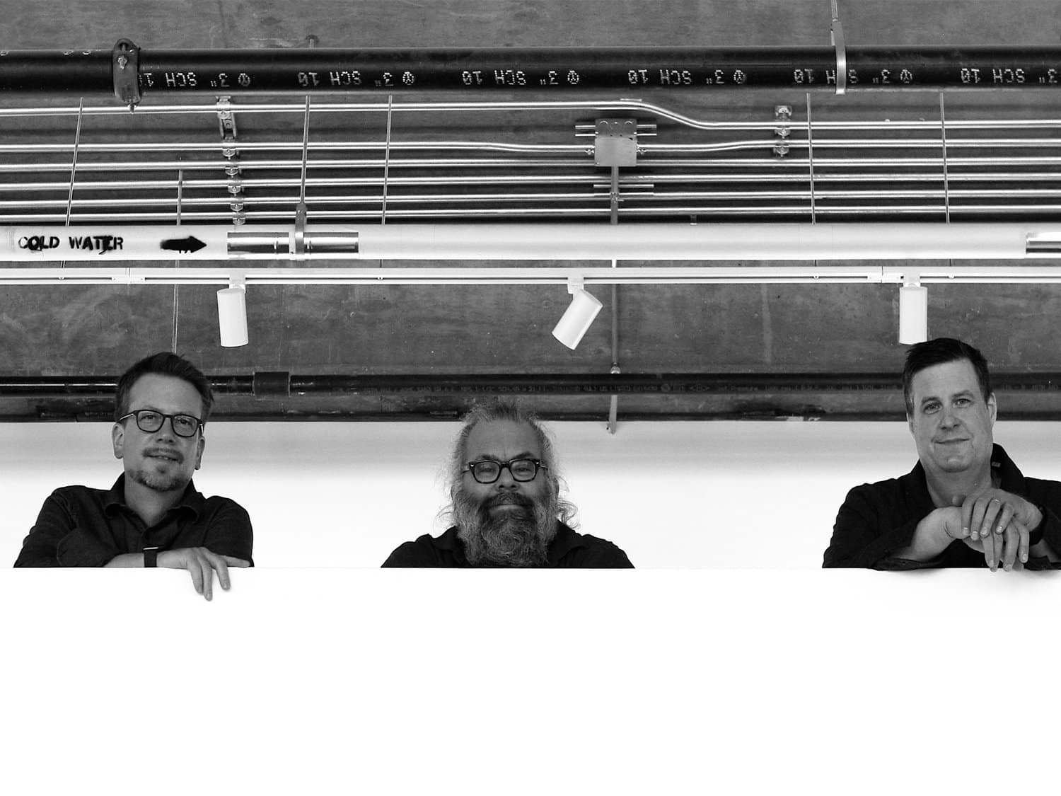 Photo: The three members of Mantis are shown looking down from a mezzanine. From left to right: Brad Townsend, Nick Zielinski, and Anders Svanoe.