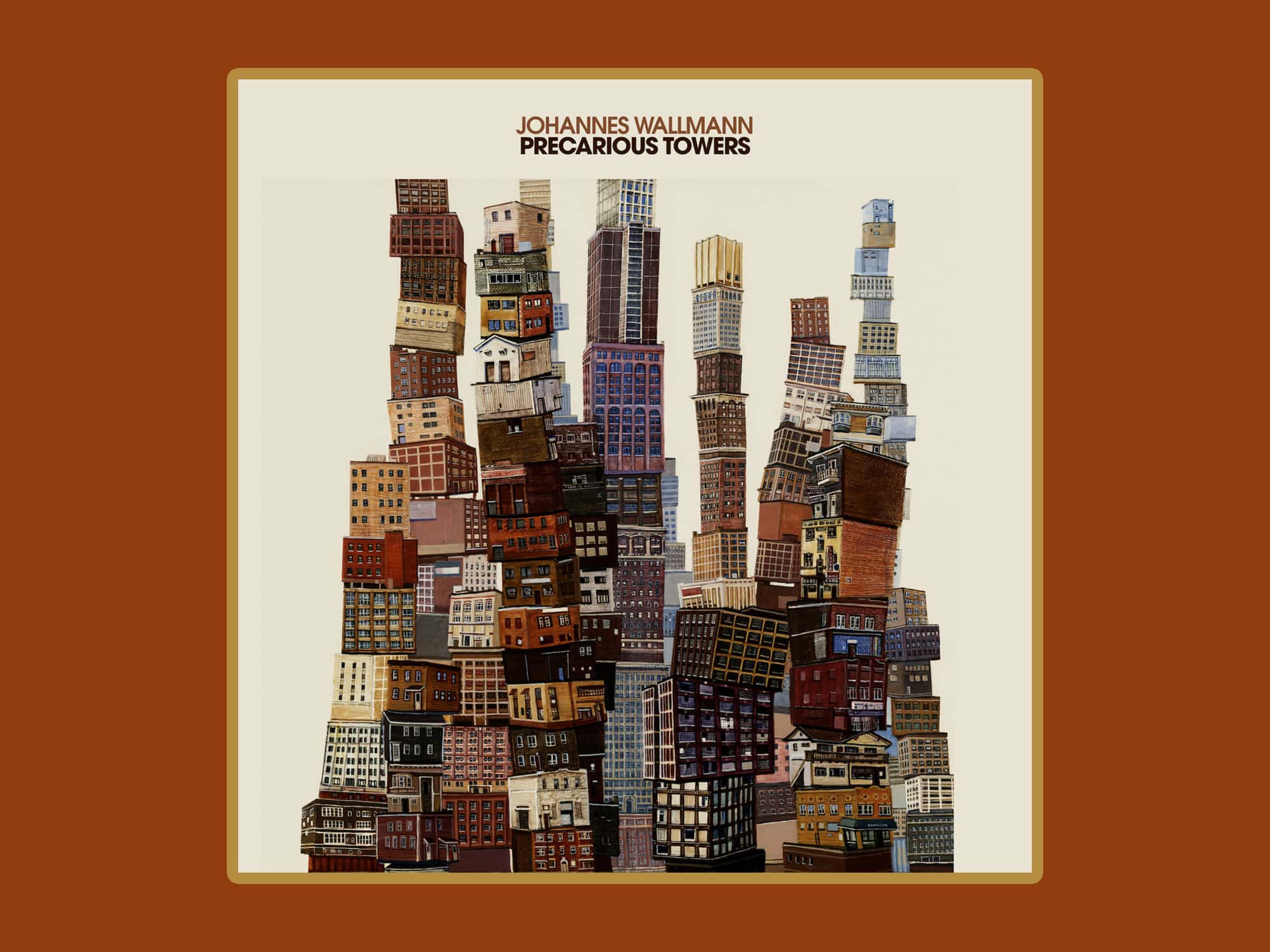 The cover art for Johannes Wallmann's album "Precarious Towers" is shown against a rusty-red background. The cover consists of a surreal collage of multiple buildings stacked on top of each other to form a series of teetering towers.