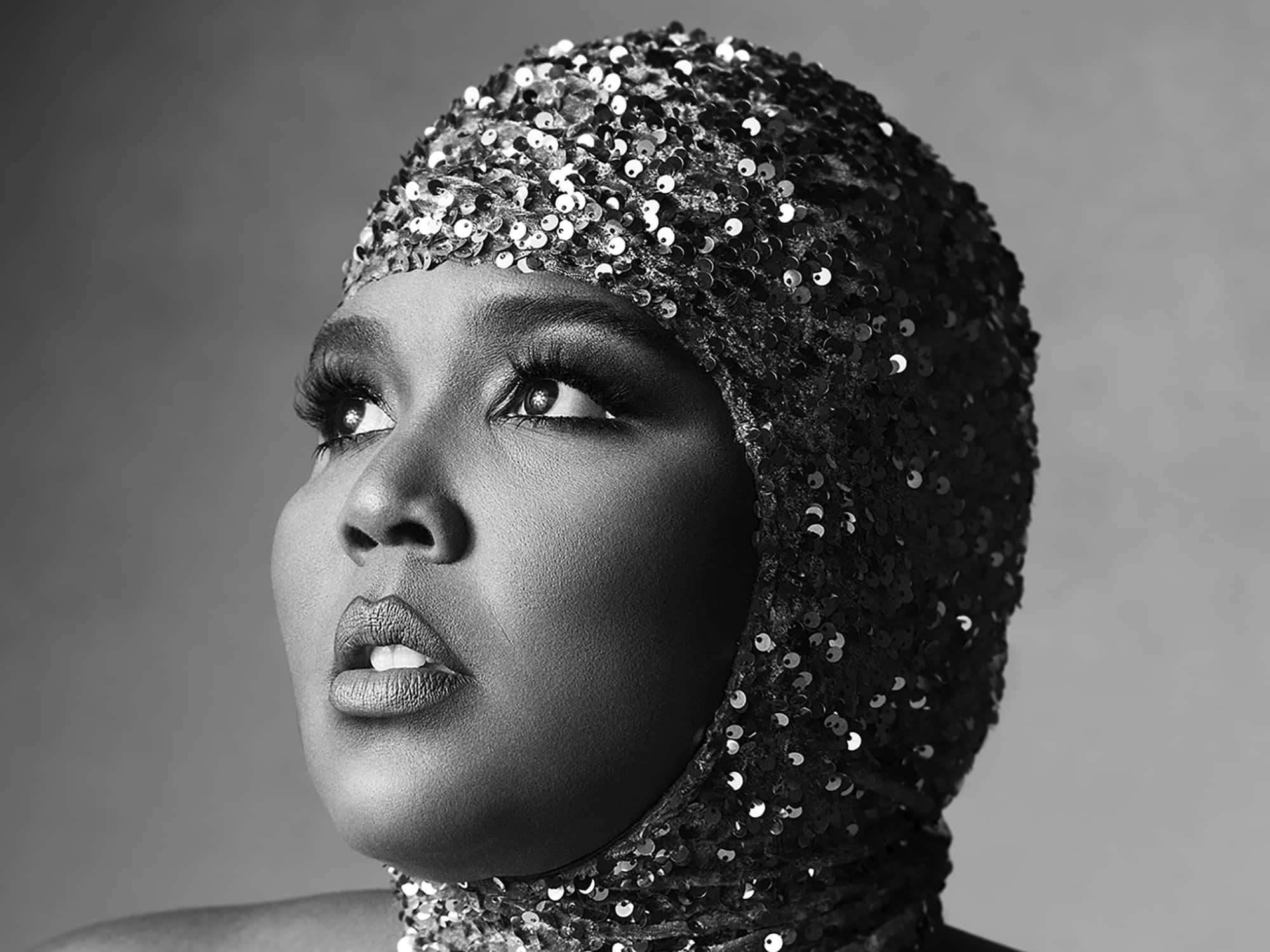In a detail from the cover of her 2022 album "Special," the artist Lizzo is shown posing in a sequined cap that covers her head and neck.