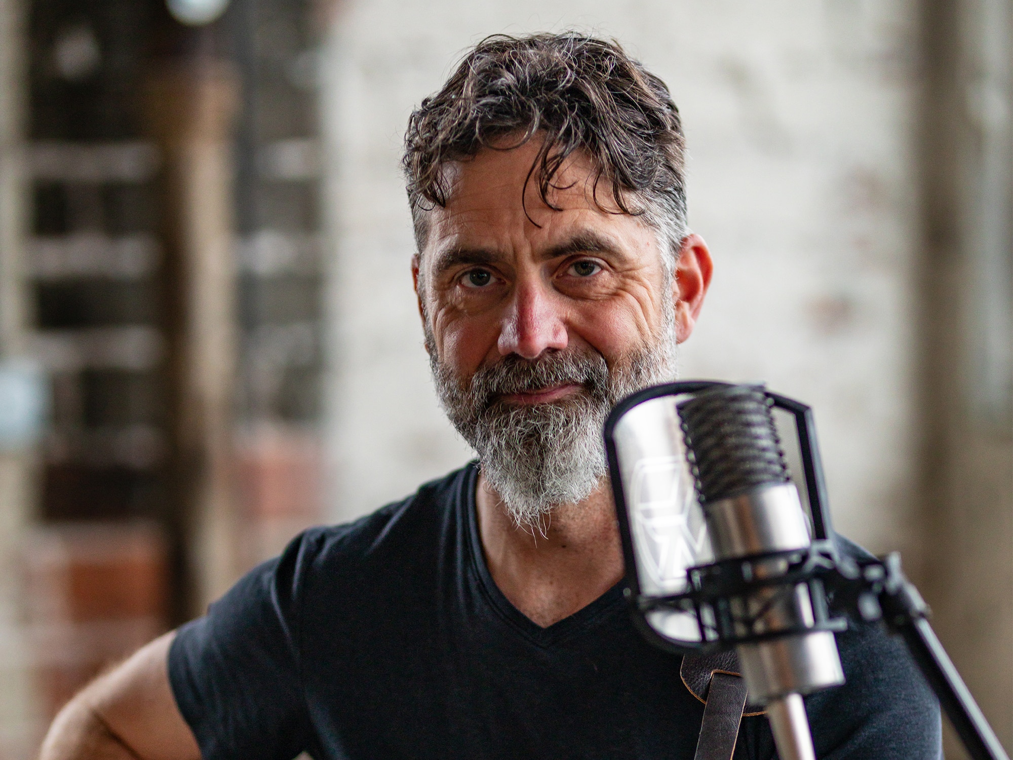 A photo shows Jeff Burkhart seated in front of a microphone. He is wearing a blue shirt and looking directly into the camera.