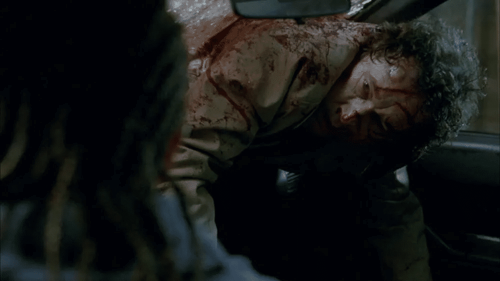 Bloodied and stuck halfway through a car windshield, Thomas (Stephen Rea) glares at Brandi (Mena Suvari) in the driver's seat.