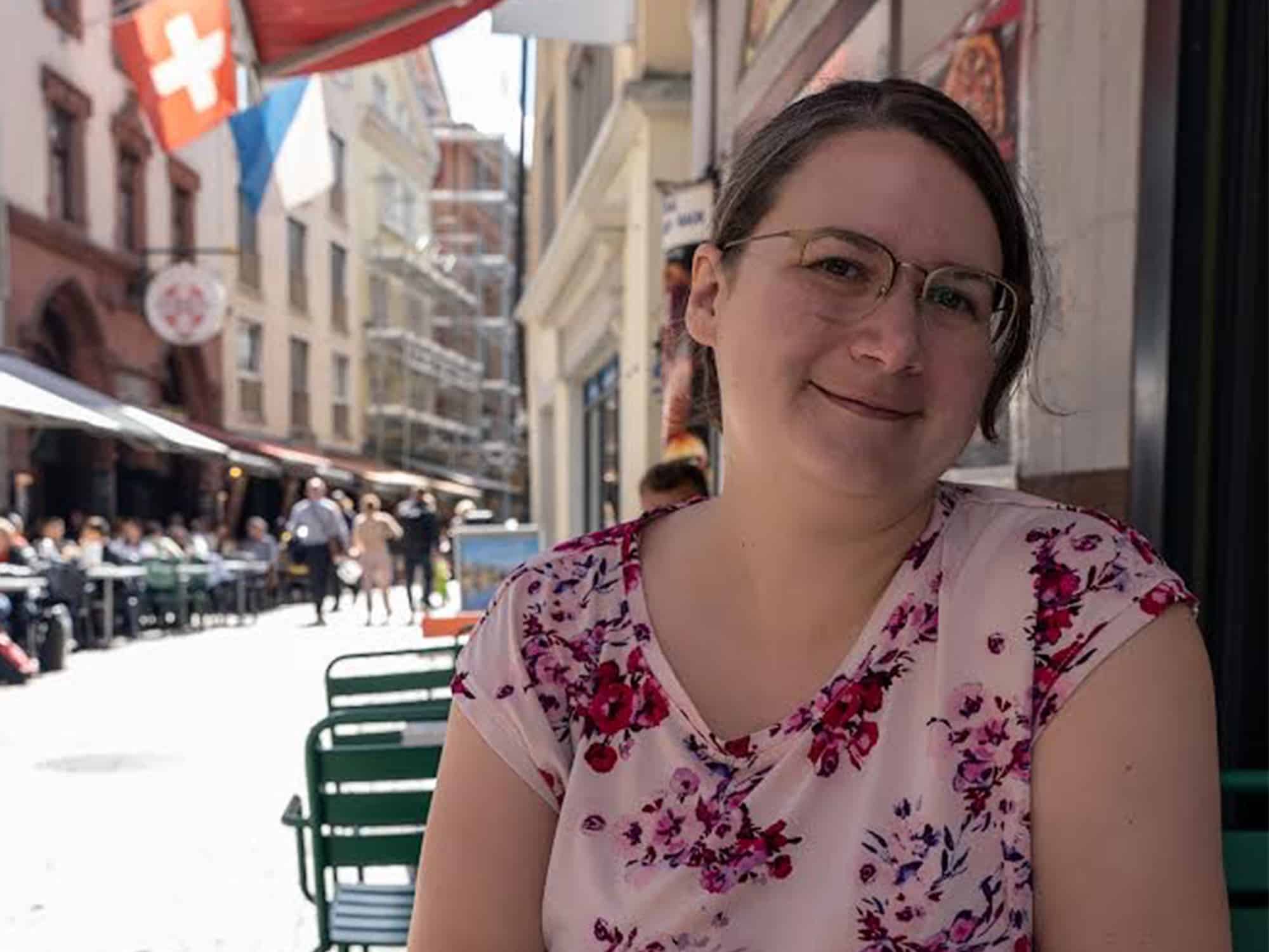 A photo shows the author seated at a table at a sidewalk cafe, facing the camera.
