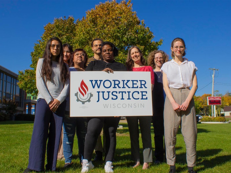 Worker Justice’s staff pose outside their office. Pictured left to right: Frida Ballard, Bowen Cao, Socorro Cortez, Robert Christl, Katrina Woods, Gretchen Baumgardt, Rebecca Meier-Rao, Caleigh Judd.