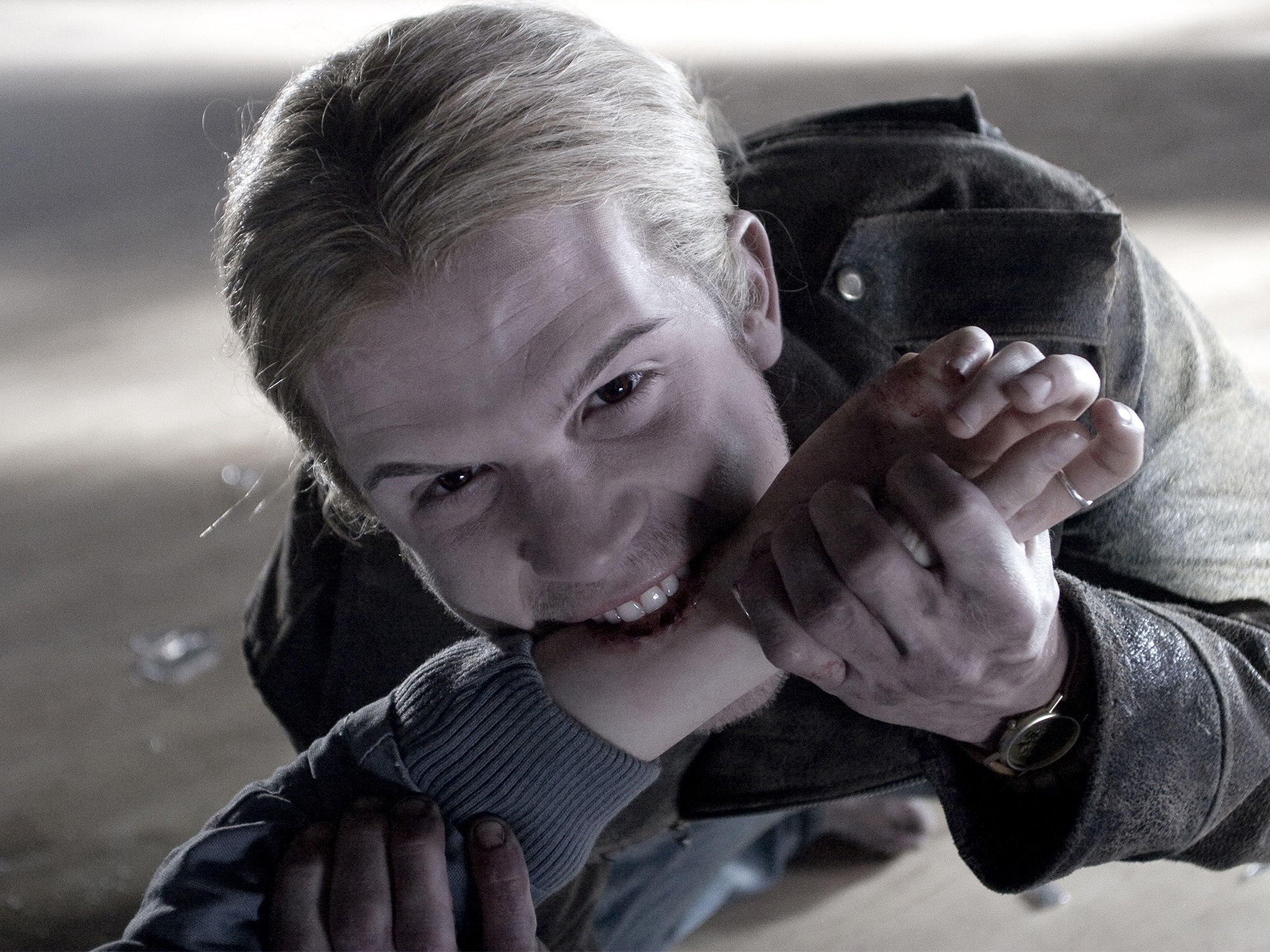 The vampire James (Cam Gigandet) is shown biting another character's wrist.