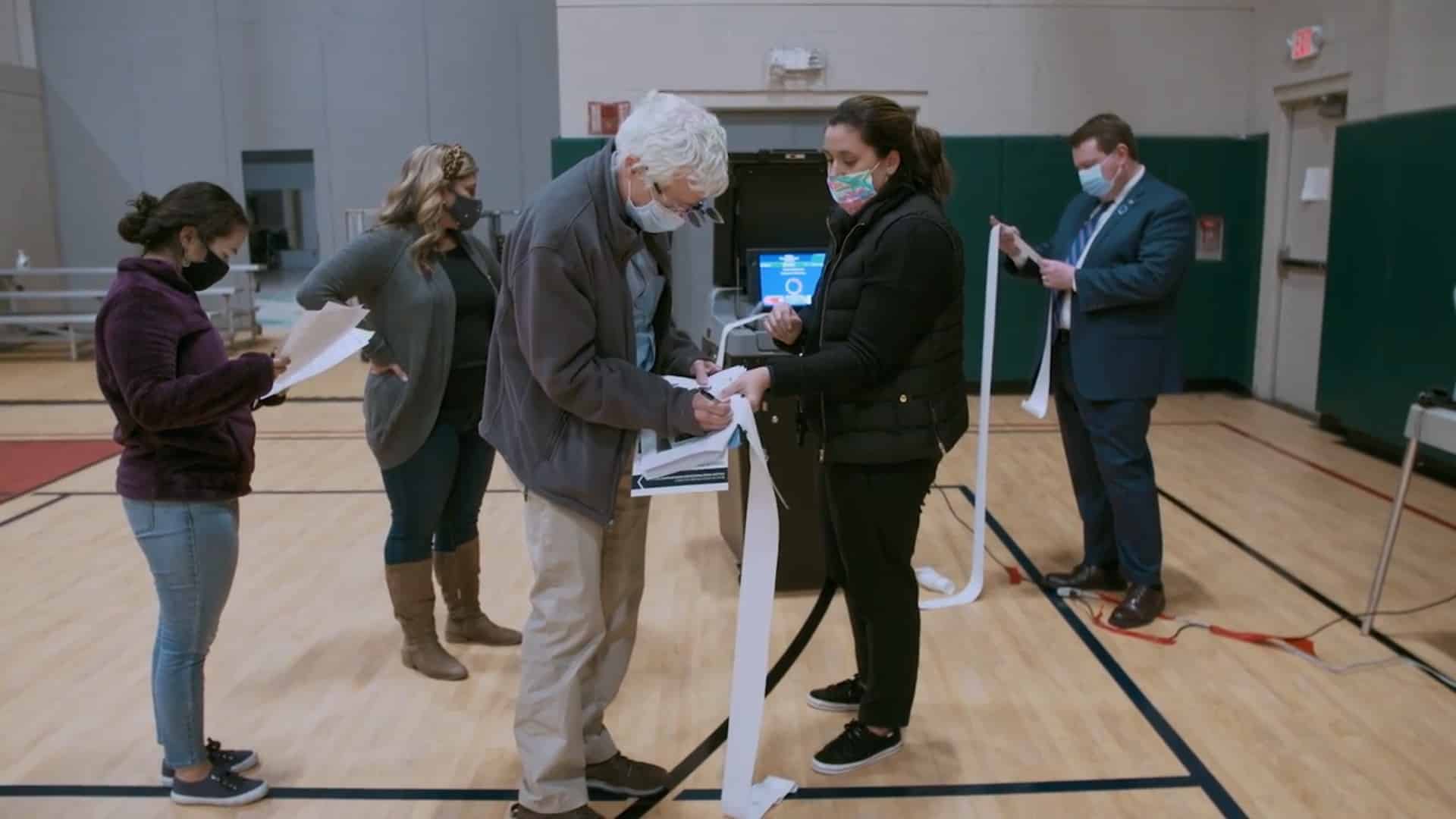 After the polls close on November 3, 2020, Rhode Island poll workers and Registrar Nick Lima (right) review the voting results printed from DS200 ballot scanners.