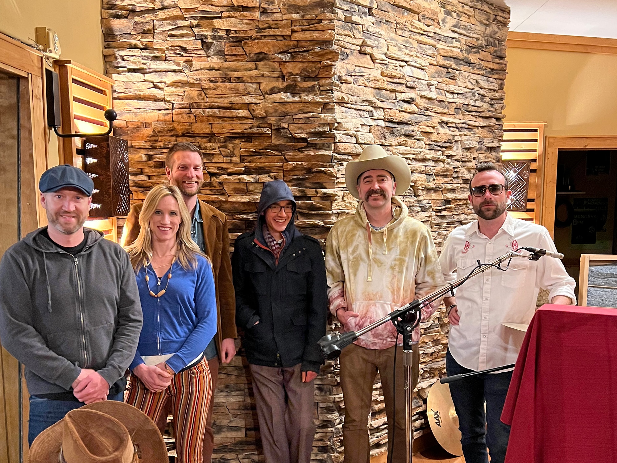 Six members of the band Cribshitter are shown posing for a photo in a recording studio.