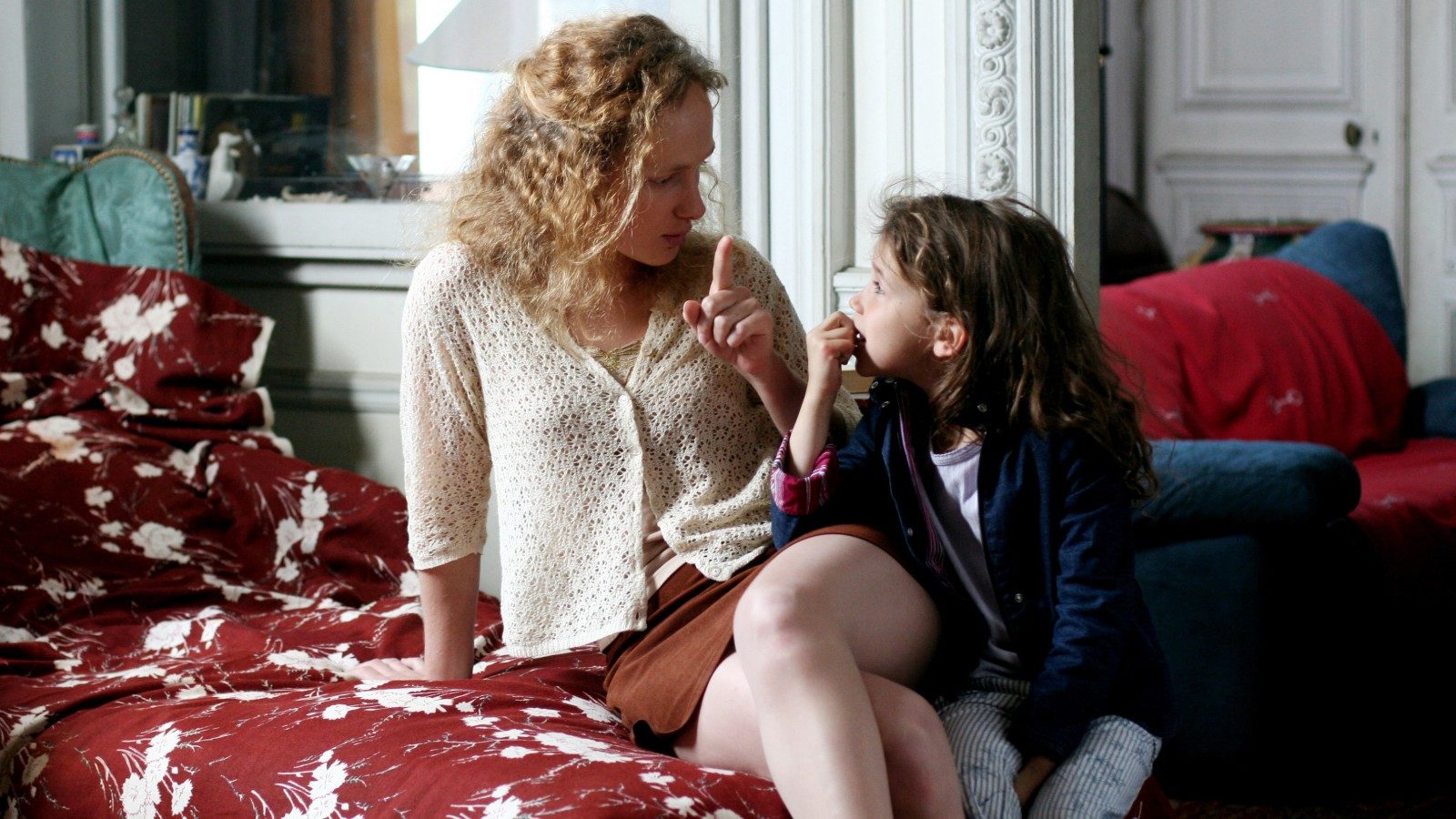 Annette (Marie-Christine Friedrich) and her young daughter Pamela (Victoire Rousseau) listen to the piano at a family gathering.