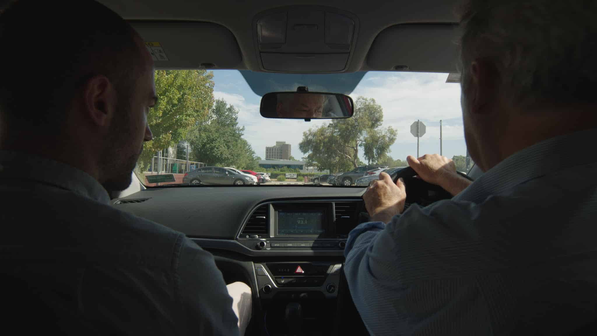 A shot from the backseat of Andrew Rakowski's Hyundai Elantra shows him (right) and director David Easteal in the passenger's seat (left) shortly after leaving their office park for the day.