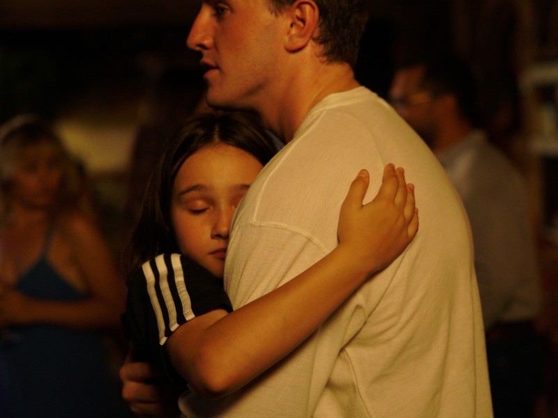 Sophie (Frankie Corio) hugs her father (Paul Mescal) as they dance together on the last night of their vacation in Turkey, one of the final moments she will spend with him.