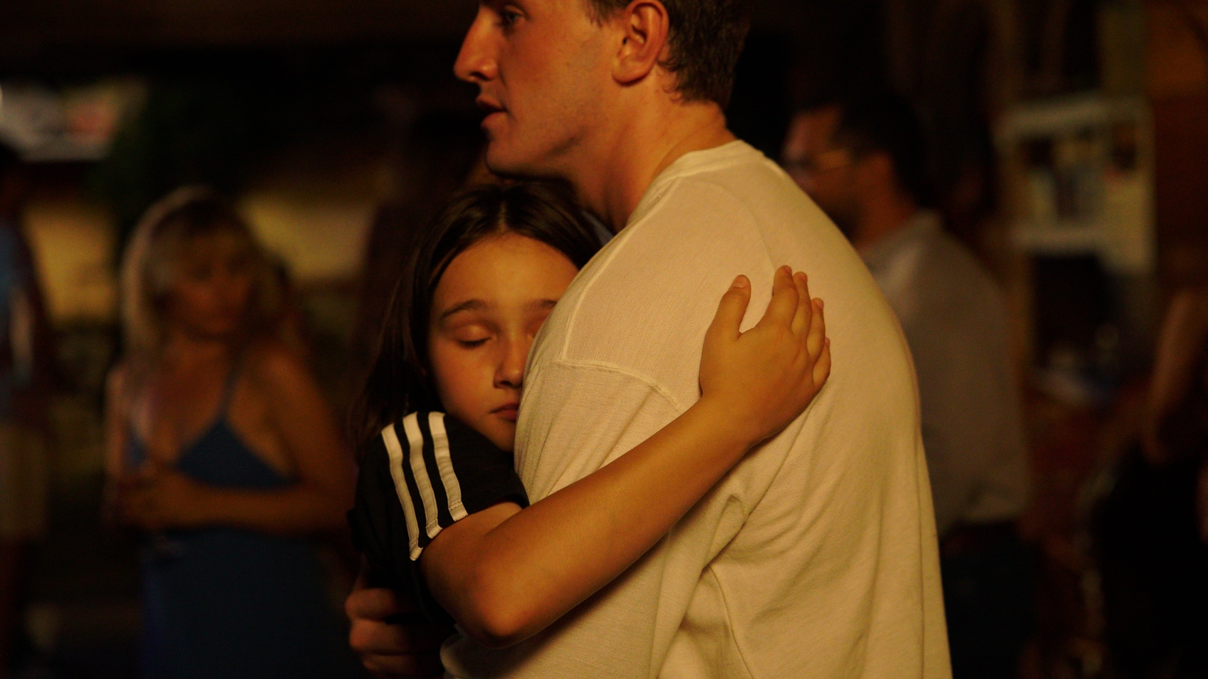 Sophie (Frankie Corio) hugs her father (Paul Mescal) as they dance together on the last night of their vacation in Turkey, one of the final moments she will spend with him.