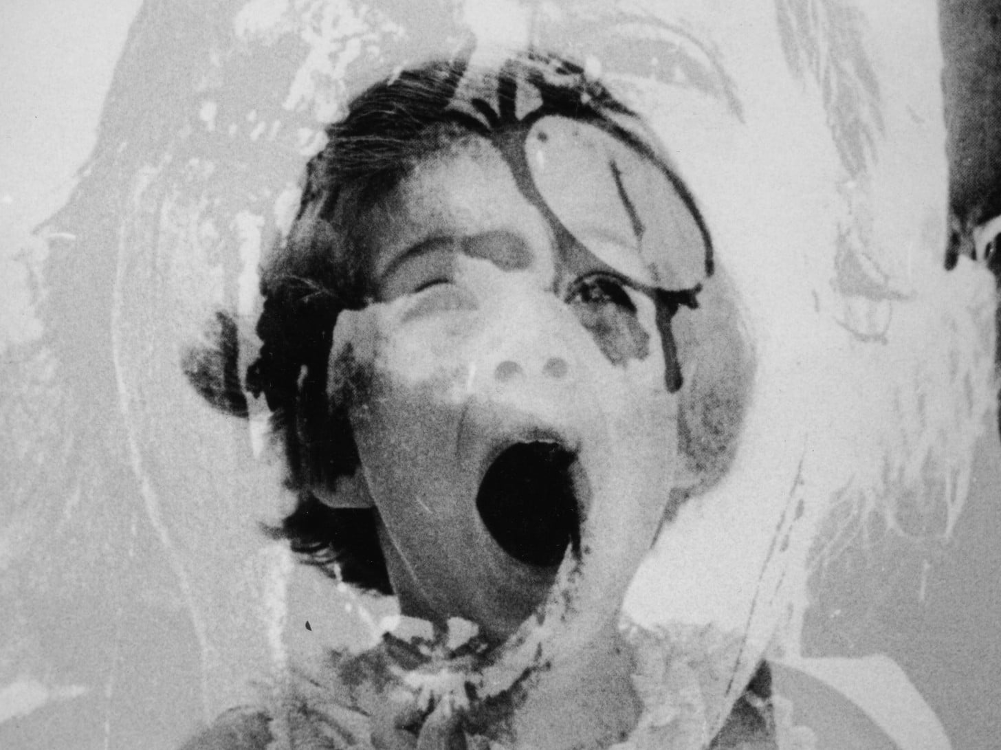 A photo of Caroline Kennedy as a child is layered with an image of a child wounded during the Vietnam War in Paolo Gioli's "Children" (2008).