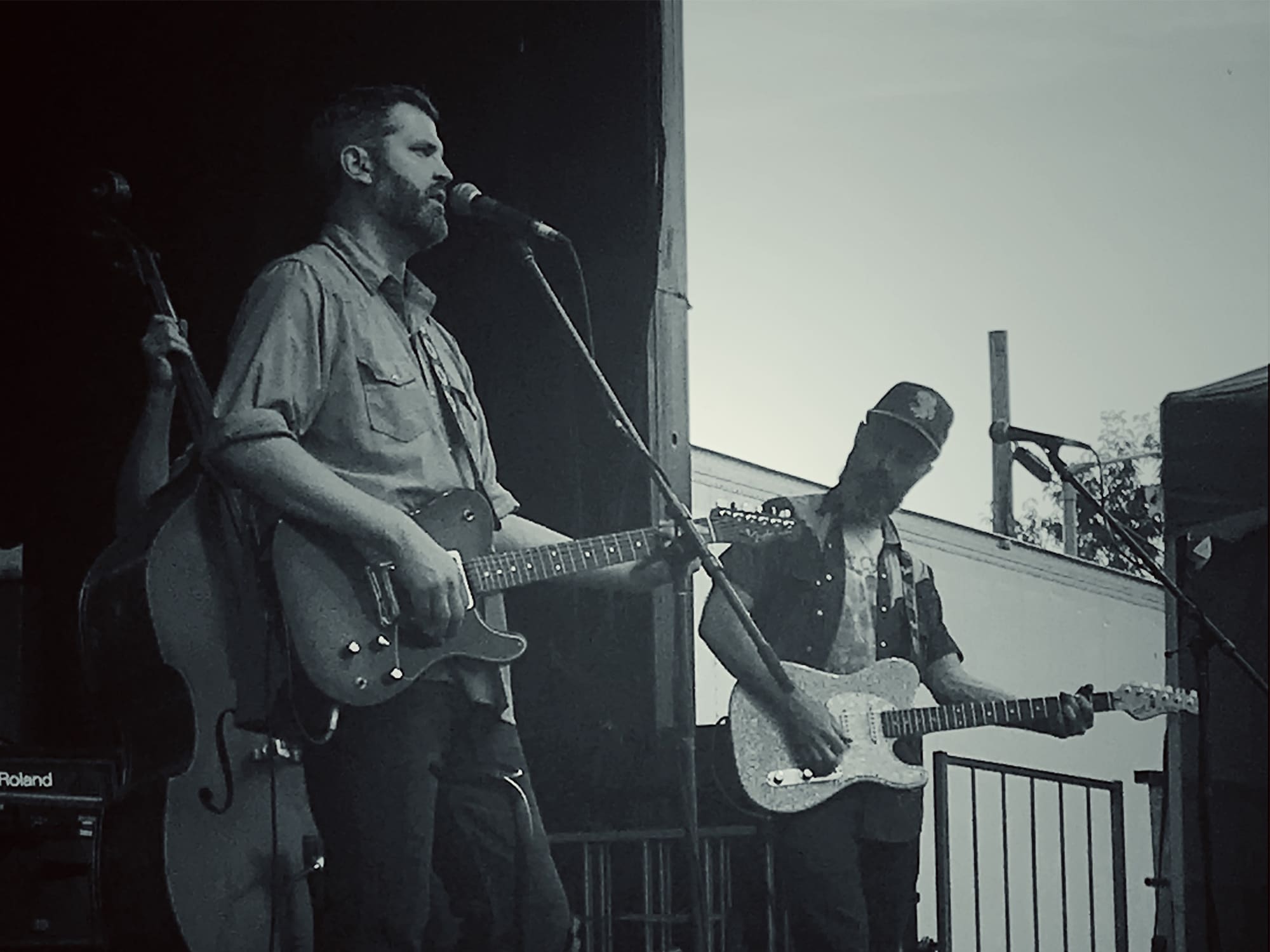A photo shows Nick Brown (left) and Andrew Harrison performing together on an outdoor stage.