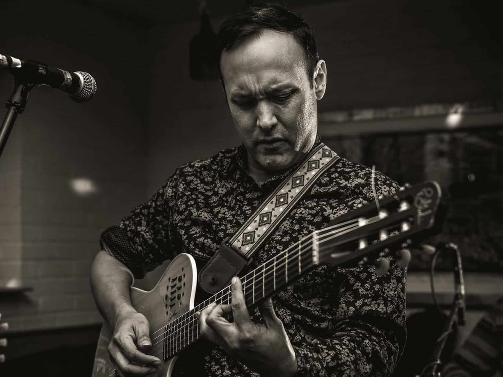 Musician Richard Hildner Armacanqui playing guitar.