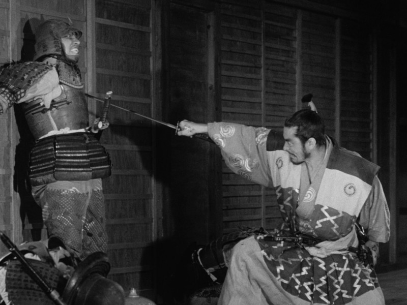 Samurai warrior Taketoki Washizu (Toshiro Mifune) brutally murders an innocent castle guard (Takeshi Kato) with his sword after assassinating his lord in his sleep.
