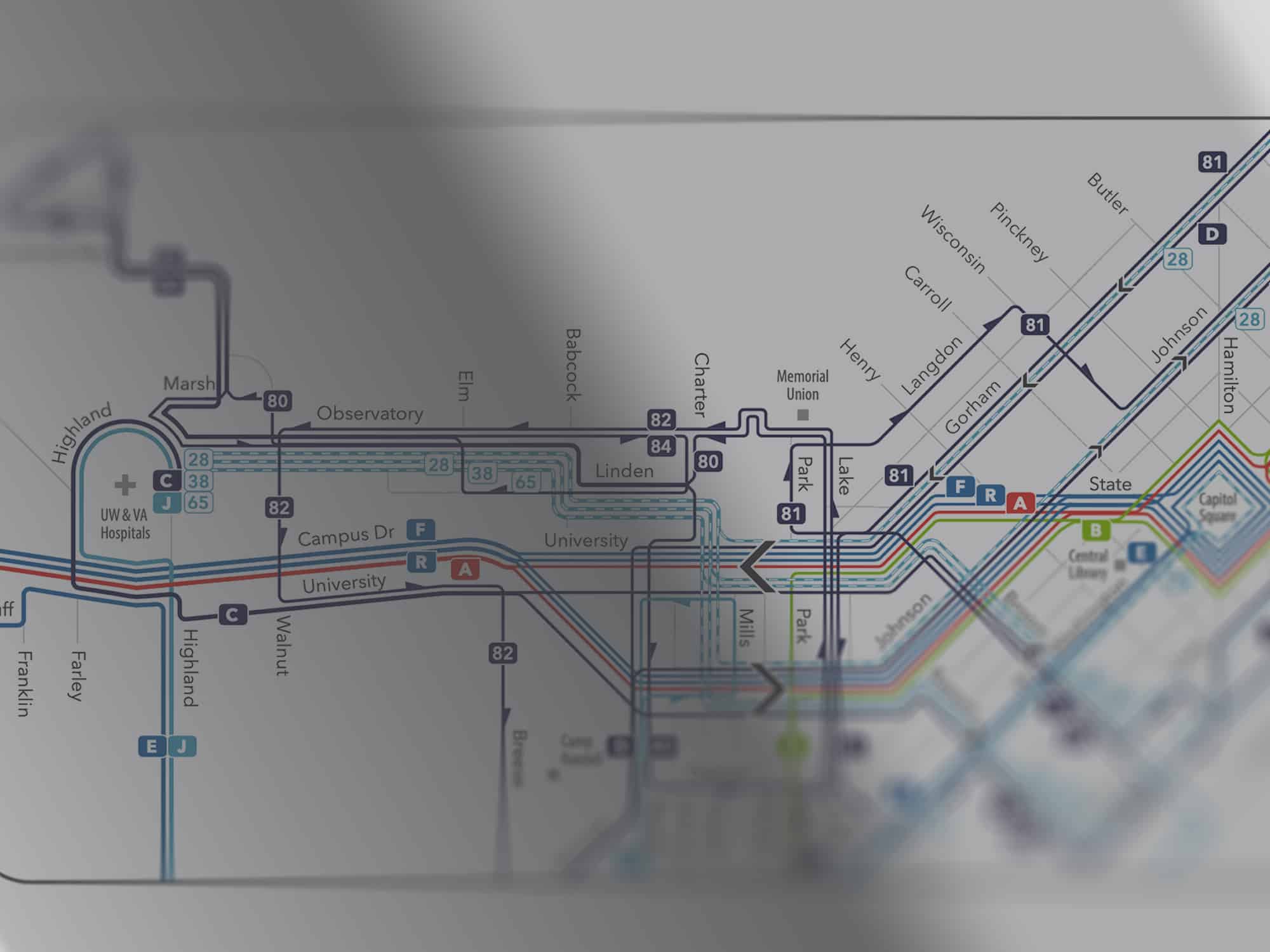 An illustration shows a downtown portion of the planned Madison Metro Transit bus route redesign, processed through filters that add blurs and shadows.