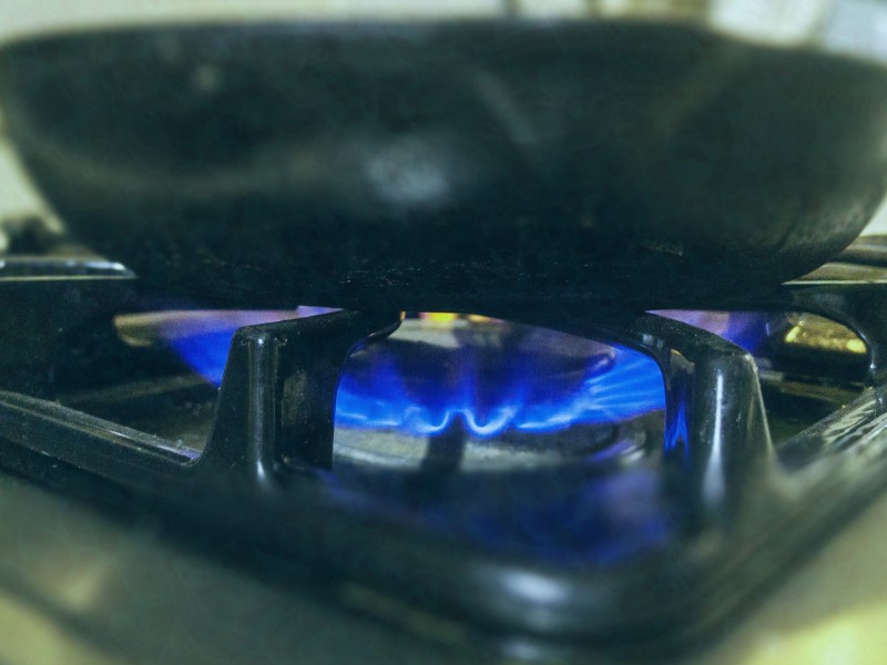 A close-up of a skillet on a gas stove burner.