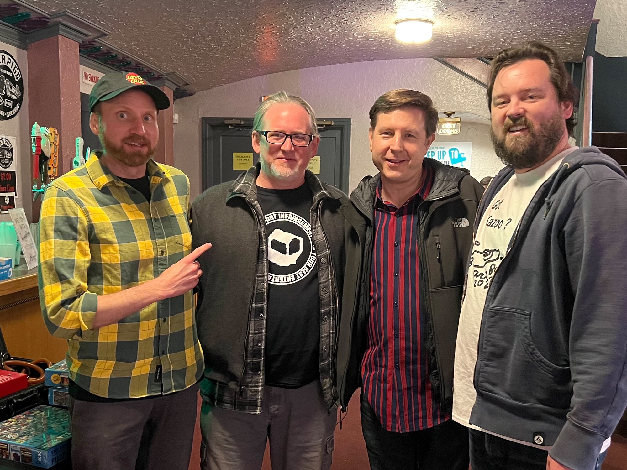 The Found Footage Festival's Nick Prueher (far left) and Joe Pickett (far right) posing with Jim's Coins owner Jim Essence (second from right) in the Barrymore Theatre lobby during a FFF event in December 2022. Photo by Harry Charles Loomer-Young.