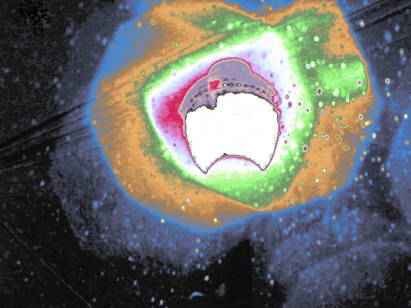 A colorful alteration of the halo of a streetlamp (with outward-moving reds, greens, yellows, and blues) on a snowy night in the short "snow light" (2023).