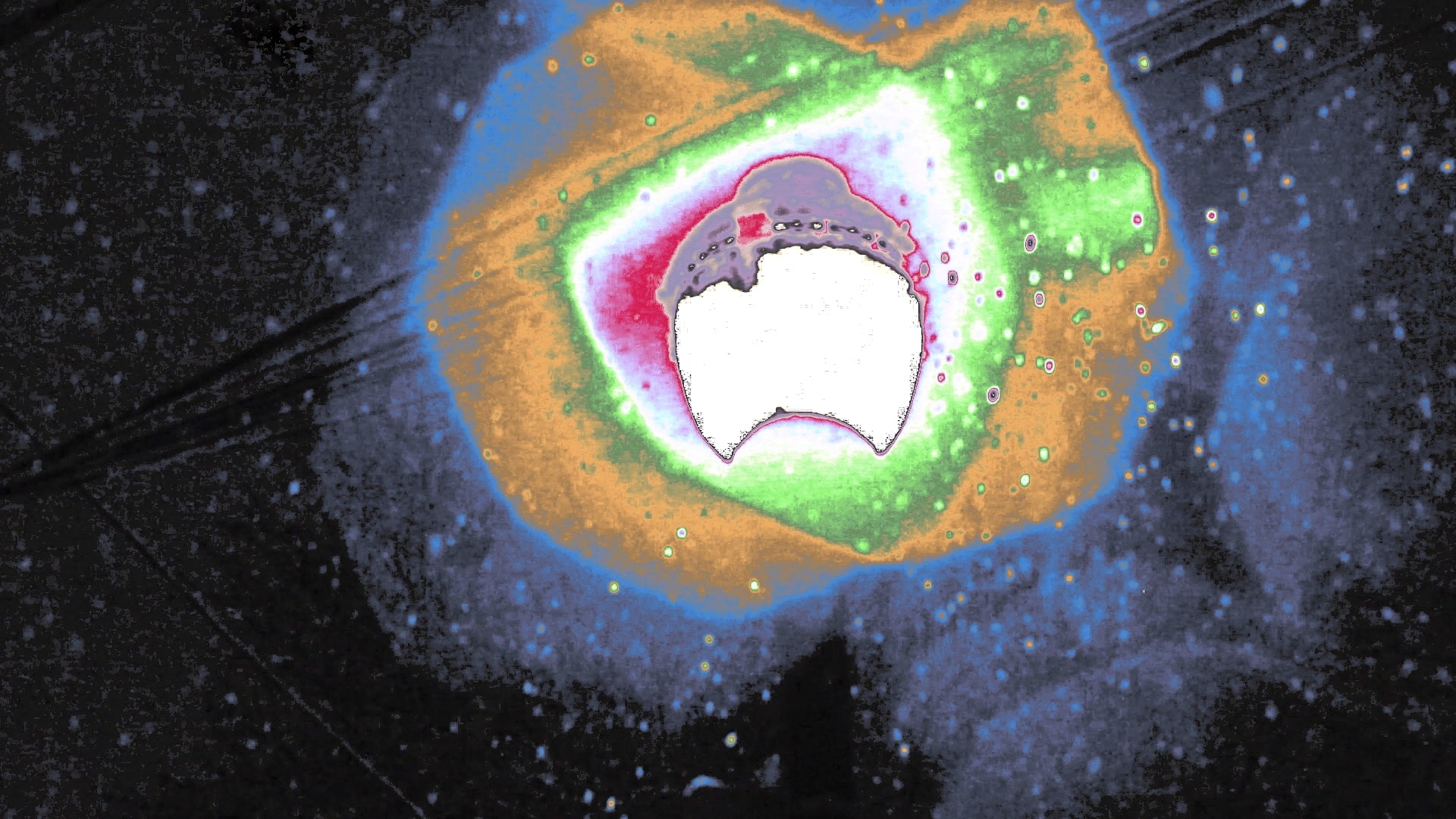 A colorful alteration of the halo of a streetlamp (with outward-moving reds, greens, yellows, and blues) on a snowy night in the short "snow light" (2023).