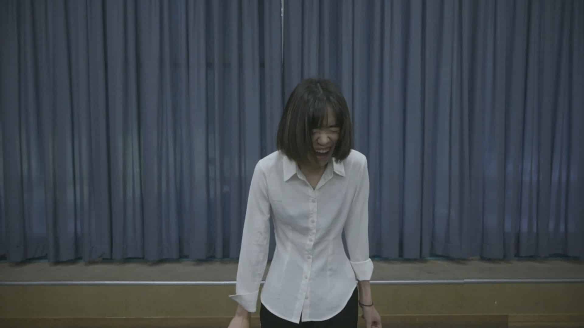 After introducing herself to the casting director, actor Yuying Tang, dressed in a white button-down shirt, "screams" the part of a humanoid robotic servant.